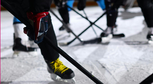 Eisfeld mit Beinen, Schlittschuhen und Eishockeyschlägern zu sehen. Close up darum sieht man nur die Beine der Spieler.