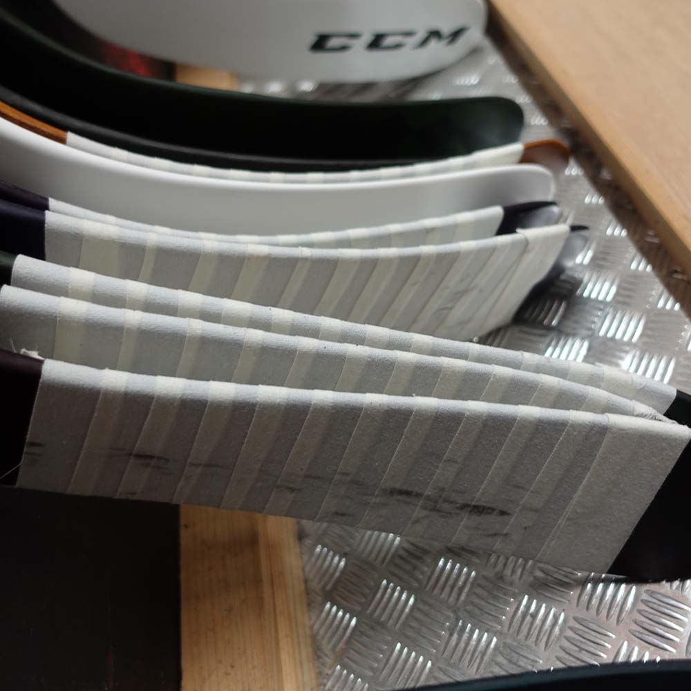 Ice hockey stick blades with white ice hockey tape on them