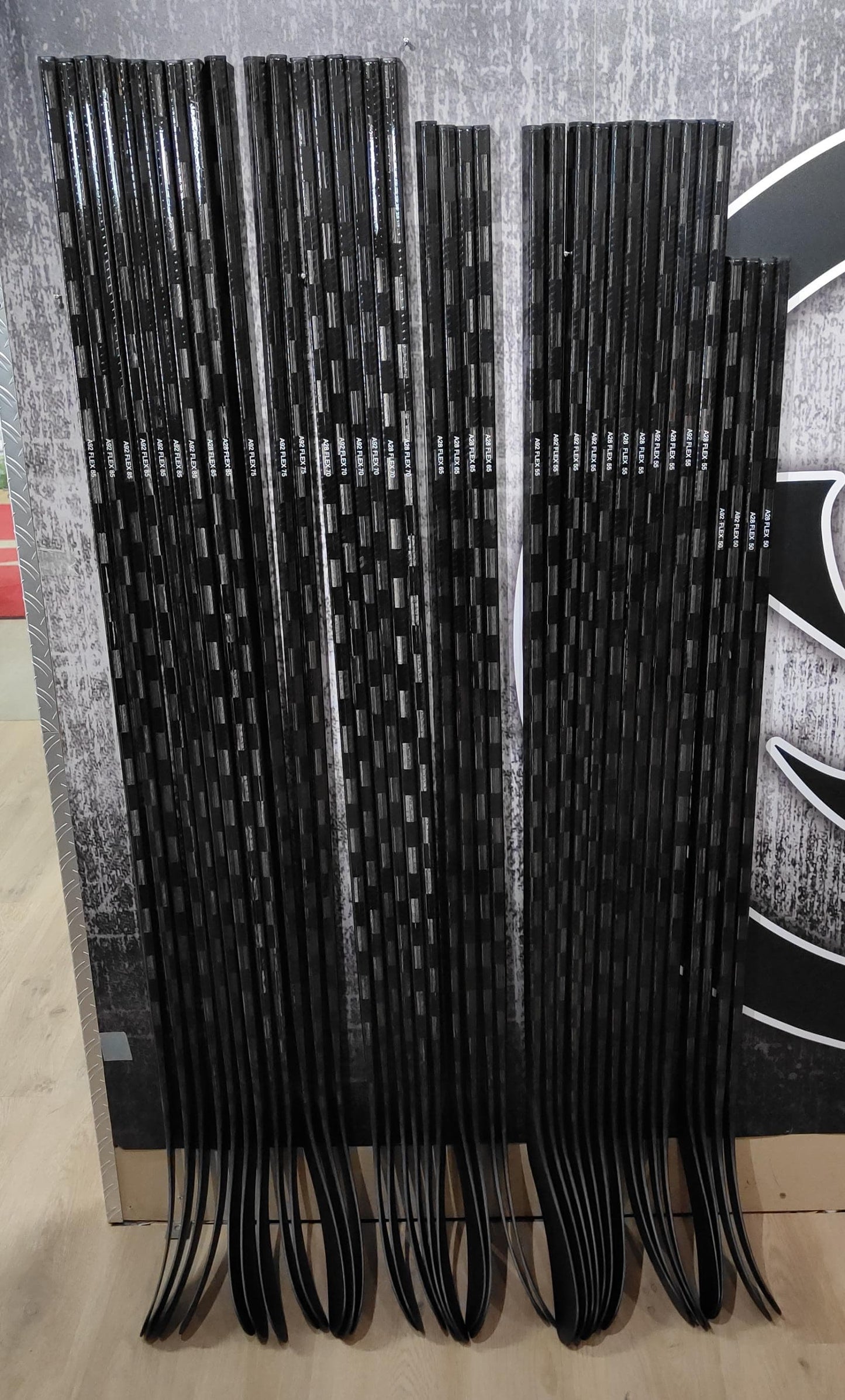 black hockeysticks stacked on wall