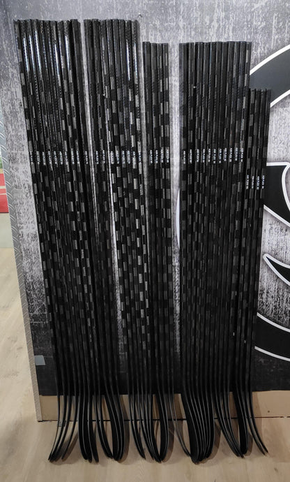 black hockeysticks stacked on wall