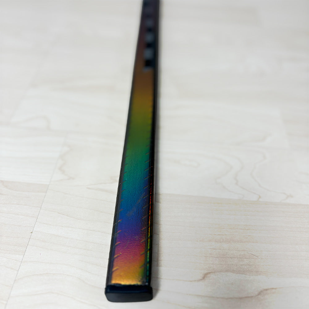 top part of the ice hockey stick lunar 1.0. the eishockeyschläger is placed on the ground and you can see the depth in the picture. Focus is on the top part with the rainbow design shining bright.